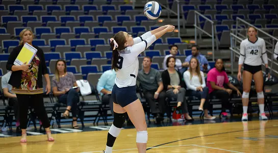 Kaileen Herman raises her arms to dig the volleyball.