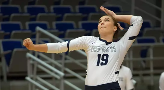 Kaileen Herman raises her left arm and eyes the volleyball before a serve.