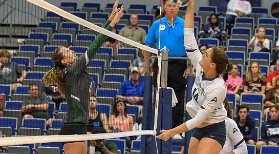 Alana Shoff strikes a ball at the net during a volleyball match.