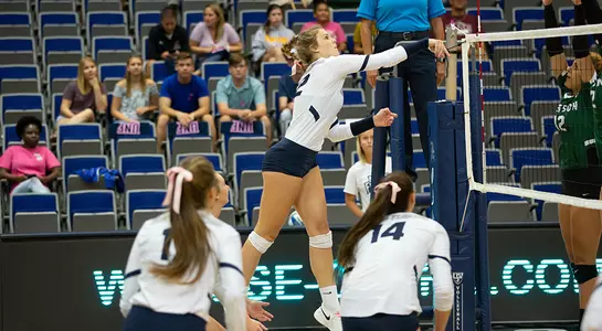 Kirby Smith follows through after hitting the volleyball just above the net.
