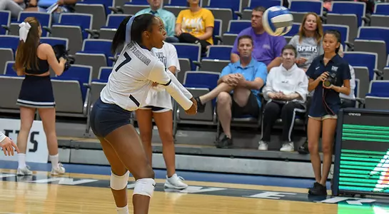 Gabby O'Connell reaches to hit a ball over the net in a volleyball match.