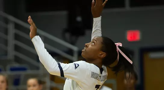 Devyn Wheeler looks up to connect with the volleyball during her serve