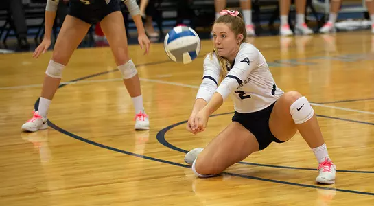 Callie Workman digs the volleyball.
