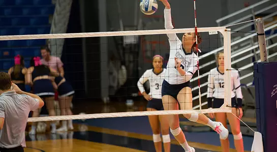 Grace Youngblood hits the volleyball near the net.