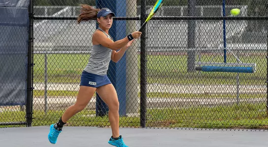 Ana Melilo returns the tennis ball at the base line.