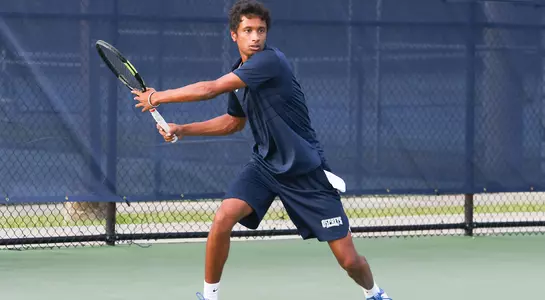 Men's tennis' Sahil Deshmukh stands at the baseline preparing for a return.
