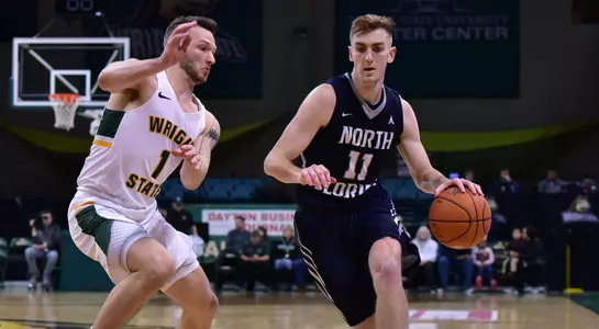 Garrett Sams dribbles the basketball past a Wright State defender