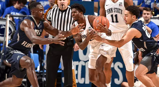 Ezekiel Balogun and Brian Coffey reach to take the ball from a Penn State player