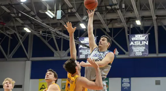 Trip Day shoots a hook shot over the outstretched hand of a defender