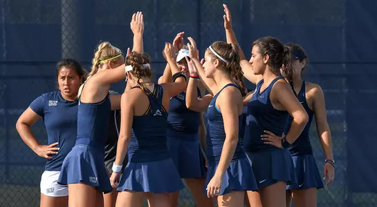 UNF women's tennis huddles after the doubles point.