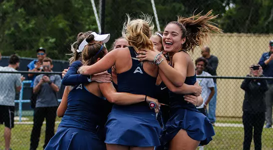 Women's tennis celebrates after winning the ASUN Tournament.