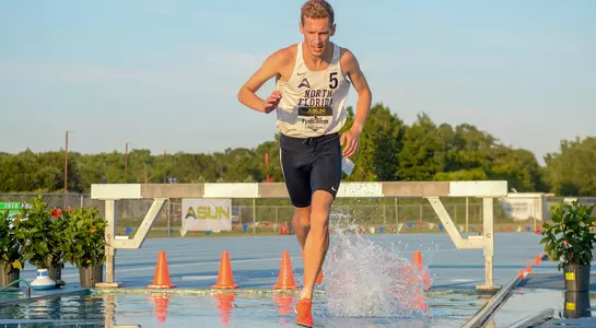 Fynn Timm clears the water hazard in the 3000-meter steeplechase
