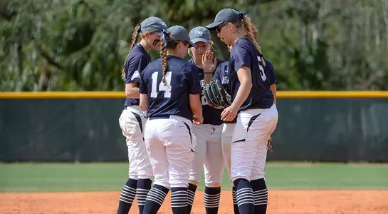 Softball infield huddles before an inning.