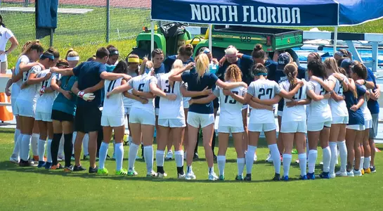 The North Florida women's soccer team huddles together on the sideline before a game