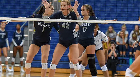 Taryn Griffey and two teammates stand and await an oncoming serve.