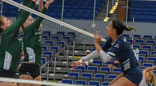 Gabby O'Connell follows through on attack attempt at the net as two USC Upstate players attempt to get in the way.