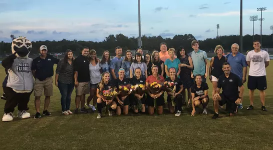 UNF women's soccer senior class poses with their families on the field before the game on Senior Night