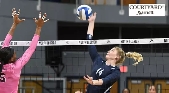 Taryn Griffey attempting a kill during a match with a Courtyard Marriott logo