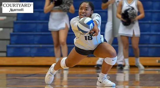 Asante Lopez diving to make a dig against USC Upstate with a Courtyard Marriott logo in the corner.