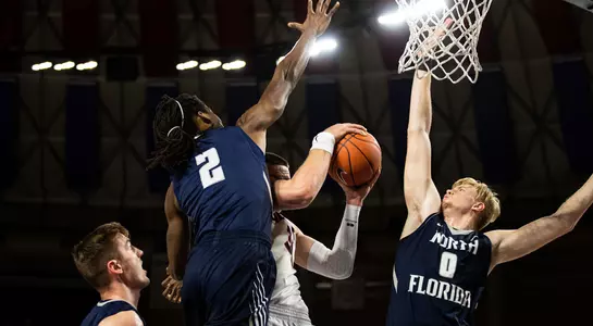 Wajid Aminu and Noah Horchler jump to block a shot by a Liberty player