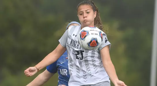 Carmel Oliveira traps a ball off her chest in front of a defender