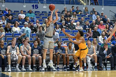 Ryan Burkhardt shoots a three-pointer over a defender