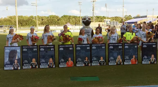 North Florida women's soccer senior class pose on sideline as a group