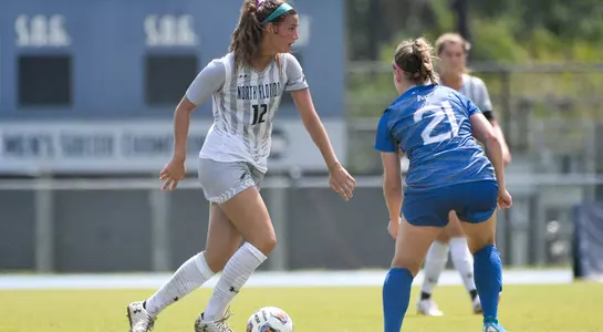 Leah Ferlin kicks the soccer ball past a defender