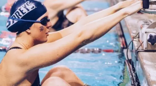 Jaqueline Barklund holds herself up on the starting block prior to start of the 100-yard backstroke event at CCSA Championship