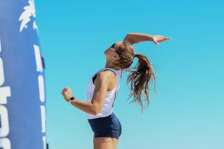 Beach volleyball action shot of Madilyn McCarty hitting the volleyball near the net.