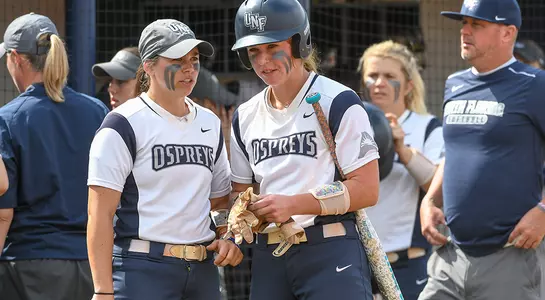 Picture of Dominica Cocuzza and Tiffany Lower talking as they are on the softball field.