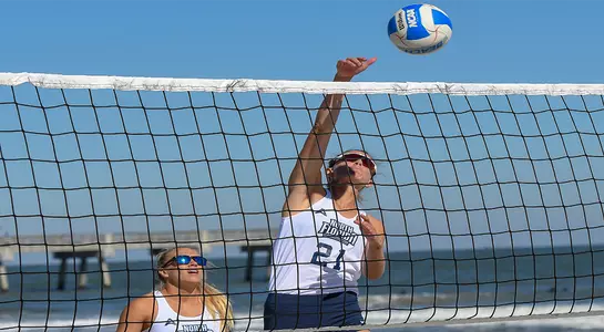 Antonia Harrison attacks the ball near the net.