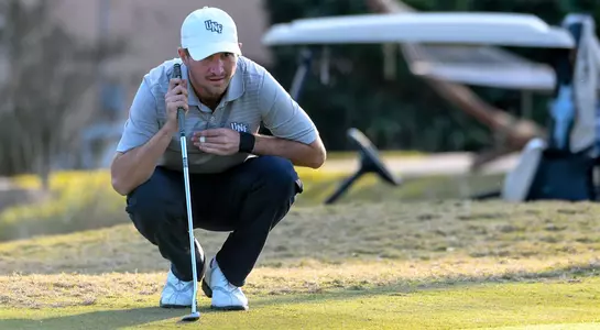 Travis Trace lines up a putt on the green