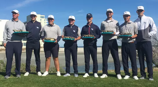 Men's golf team poses with trophy after winning the General Hackler Championship