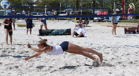 Carolyn Cain dives for a beach volleyball.