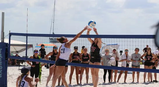 Antonia Harrison leaps up at the net to contend with an opponent.