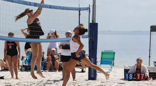 Brittany Pase hits the ball near the net.