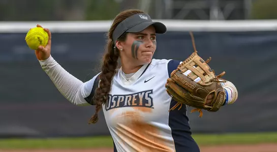 Action shot of softball player Makenzie Griffin throwing over to first base.