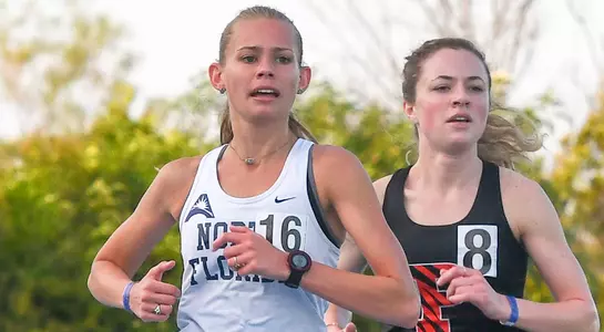 Audrey Carpenter runs beside another runner towards the finish line