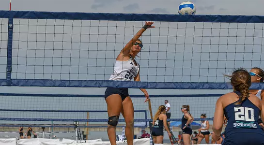 Marisa Rogers spikes ball over the net at UNF Invitational