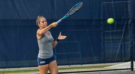 Rafaela Gomez returns the ball at the tennis court.