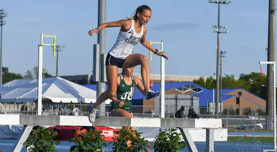 Audrey Carpenter jumps over the water hurdle in the 3000 meter steepelchase
