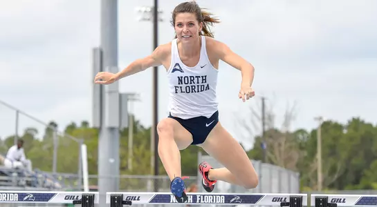 Jade Sullivan jumps over the hurdle on the track