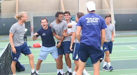 The North Florida men's tennis team surrounds Sahil Deshmukh after he clinched the match.