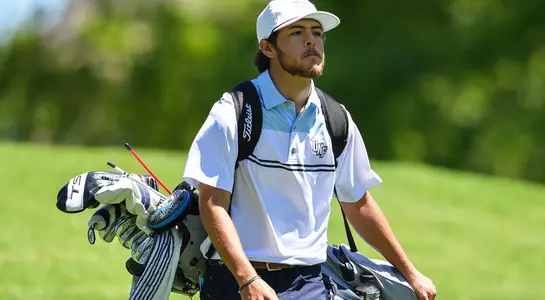 Jordan Batchelor carries his golf bag as he walks down the fairway at the ASUN Championship