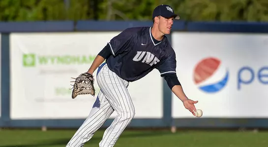 baseball player Alex Reynolds flipping the ball towards first