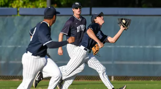 baseball team Tanner Murphey, Abraham Sequera watch as Blake Marabell catches ball