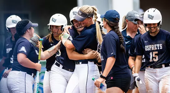 Paige Pfent gets hugged by Morgan Clausen after hitting a grandslam.