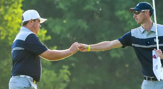 Michael Mattiace gives a fist bump to assistant coach Jeff Dennis after hitting a tee shot