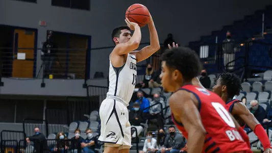 Jose Placer shoots a jump shot over a defenders hand
